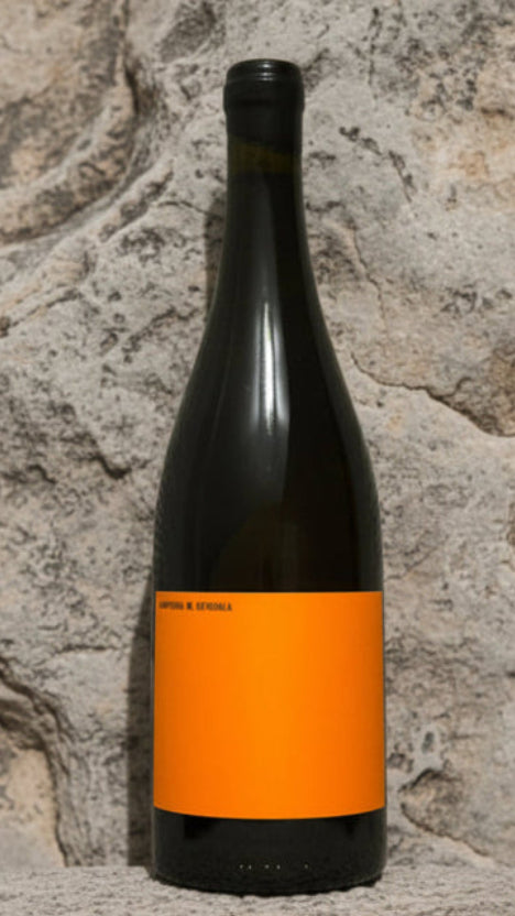 Wine bottle with an orange label on a stone surface